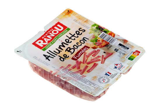 Barquette d'allumettes de bacon fum&eacute;es de la marque Monique Ranou en gros plan sur fond blanc