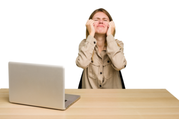 Young caucasian woman in a workplace working with a laptop isolated crying, unhappy with something, agony and confusion concept.