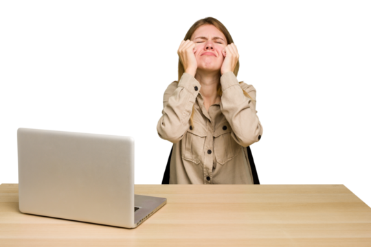 Young caucasian woman in a workplace working with a laptop isolated crying, unhappy with something, agony and confusion concept.