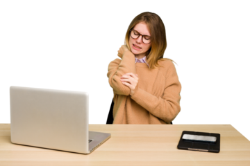 Young caucasian woman in a workplace working with a laptop isolated massaging elbow, suffering after a bad movement.
