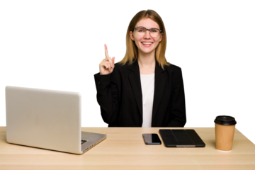 Young business caucasian woman working on her workplace cutout isolated showing number one with finger.