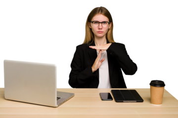 Young business caucasian woman working on her workplace cutout isolated showing a timeout gesture.