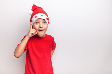 a little santa, a child in a red hat on Christmas Eve thinks about a gift. white background, studio, isolated,