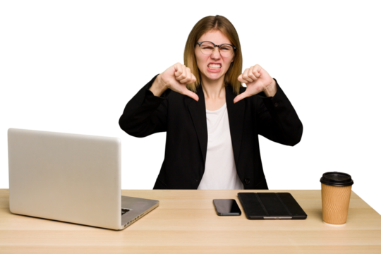 Young business caucasian woman working on her workplace cutout isolated showing thumb down and expressing dislike.