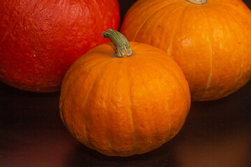 Yellow-orange pumpkins on a black background the concept of Halloween and the autumn harvest of pumpkin close-up copyspace from above
