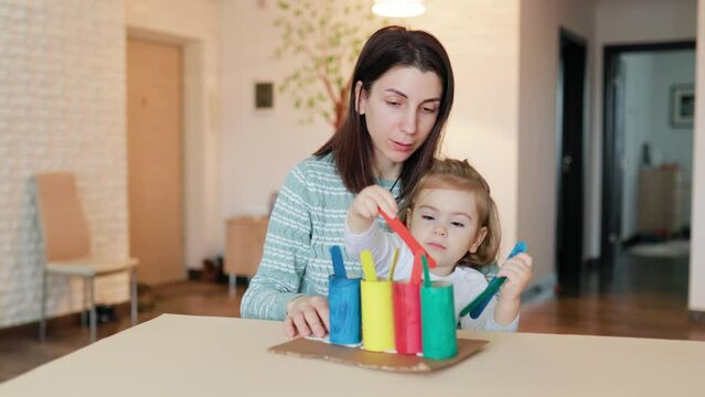 young mother is engaged with her daughter according to the Montessori method. The concept of early development. A small child enjoys playing useful games.