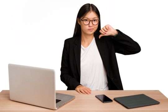 Young business asian woman sitting on a table isolated showing thumb down, disappointment concept.