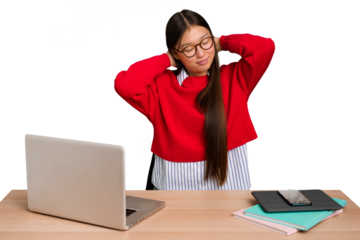 Young student asian woman in a workplace with a laptop isolated feeling confident, with hands behind the head.