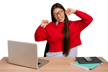 Young student asian woman in a workplace with a laptop isolated celebrating a special day, jumps and raise arms with energy.