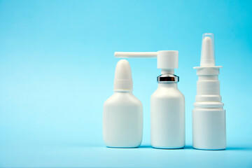 Nasal spray bottle on blue background with copy space