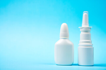Nasal spray bottle on blue background with copy space