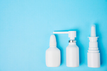 Nasal spray bottle on blue background with copy space