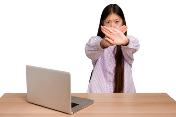 Young student asian woman in a workplace with a laptop isolated doing a denial gesture