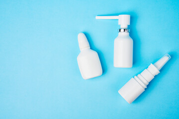 Nasal spray bottle on blue background with copy space