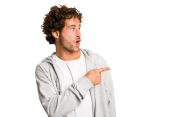 Young curly smart caucasian man cut out isolated points with thumb finger away, laughing and carefree.