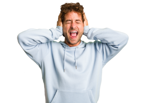 Young curly smart caucasian man cut out isolated covering ears with hands trying not to hear too loud sound.