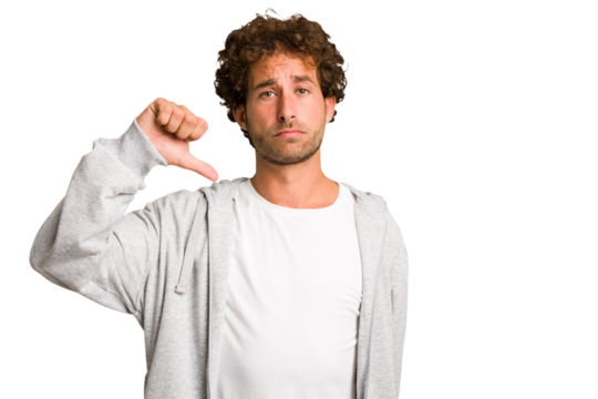 Young curly smart caucasian man cut out isolated showing a dislike gesture, thumbs down. Disagreement concept.
