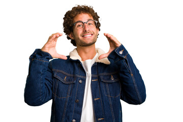 Young curly smart caucasian man cut out isolated holding something with palms, offering to camera.