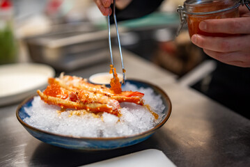 chef cooking crab legs with caviar on kitchen