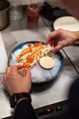 chef cooking crab legs with caviar on kitchen
