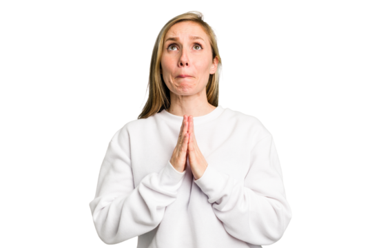Young caucasian woman cutout isolated holding hands in pray near mouth, feels confident. - Powered by Adobe
