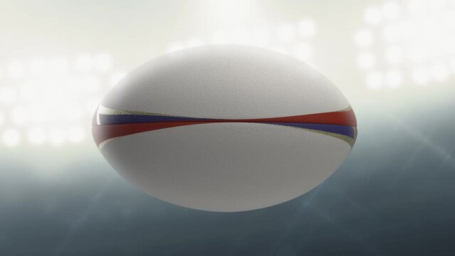 A seamlessly loop able animation of a white textured rugby ball with red blue and gold colour design element spinning and rotating on floodlit stadium background in the night time