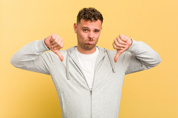 Fototapeta premium Young caucasian handsome man isolated on yellow background showing a dislike gesture, thumbs down. Disagreement concept.