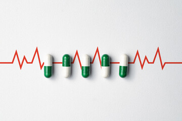 Medical pills on white background with copy space, and heart rate icon