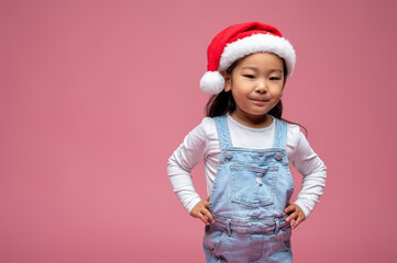 Cute little girl in santa hat looking happy and sweet