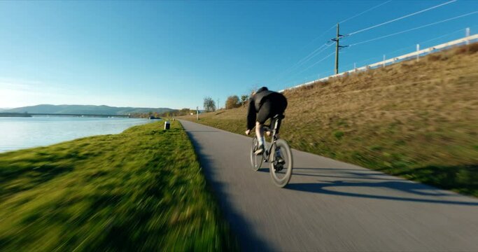 FPV following Jake the Fixedgear Biker next to Danube River during sunny autumn day.