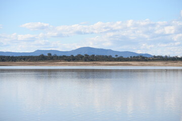 Lake Keepit in winter morning with still water, trees, and blue hills in backdrop, NSW, Australia