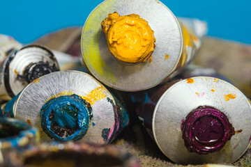 macro view of tubes of oil paint of different colors. Used oil paint tubes. Yellow and blue oil...