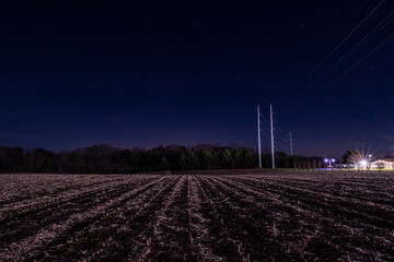 Lusby, Maryland USA A plowed field at night and power lines.