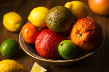 Juicy citrus fruits in a large bowl on a dark background
