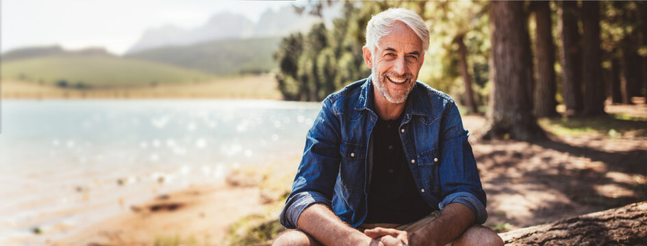 Happy and healthy senior man smiling while enjoying an active lifestyle in nature and outdoor camping