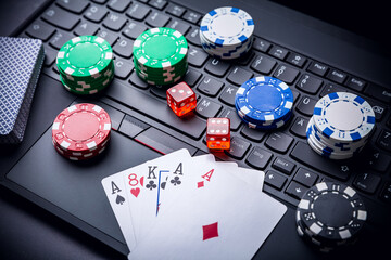 Online poker. Chips, cards and dice nearby keyboard