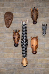 African masks hanging on a brick wall