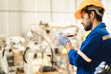 Male industrial engineer wears safety helmet examining lathe steel in metalwork factory. Engineering technician working with stainless molding process in heavy machinery workshop. Metal tool industry.