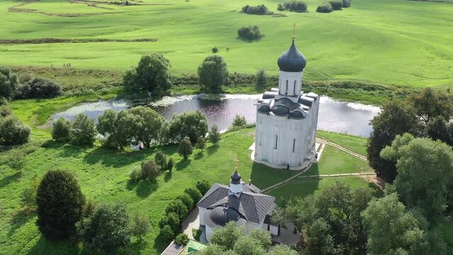 Aerial view of the ancient white-stone Church of the Intercession on the Nerl on a summer day, which is a historical monument and one of the most unique temples in Russia, Vladimir region. 