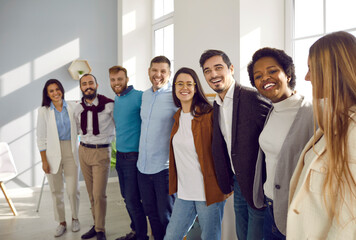 Support and union. Portrait of happy multiracial business colleagues and friends hugging and...