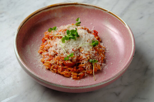 Cherry tomato sugo risoni in a pink bowl