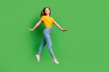 Full body portrait of overjoyed adorable person jumping have good mood isolated on green color background