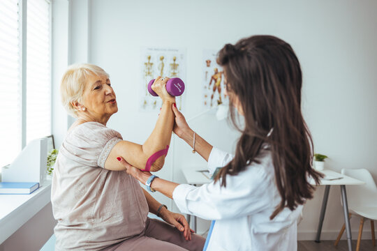Female doctor examining senior patient suffering from elbow pain. Medical exam. Chiropractic, osteopathy, post traumatic rehabilitation,sport physical therapy. 