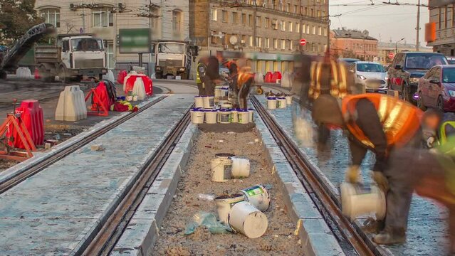 Tram rails at the stage of their installation and integration into concrete plates on the road timelapse. Filling by liquid resin for reduction of vibration and noice. The process of reconstruction of