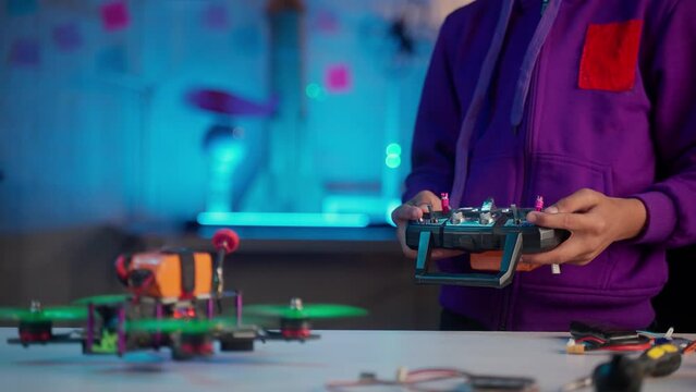 Close up shot of kid flying drone with holding controller remote at home - concept of inspiration, scientist and technology