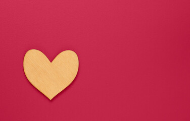 Natural wooden heart on dark Viva Magenta color background.