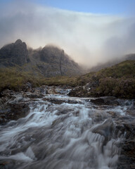 Morning view of river in the foreground and cloud covered mountain range. Scenic summer landscape with river in the morning. Bla Bheinn, Isle of Skye, Scottish Highlands, UK.