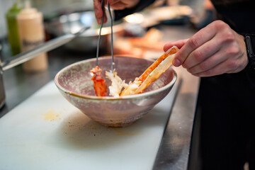 Close up hand of chef in restaurant cooking crab leg
