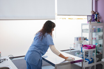 Female veterinarian cleaning the examination table.