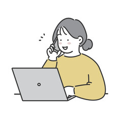 パソコンを操作しながら電話をかける女性